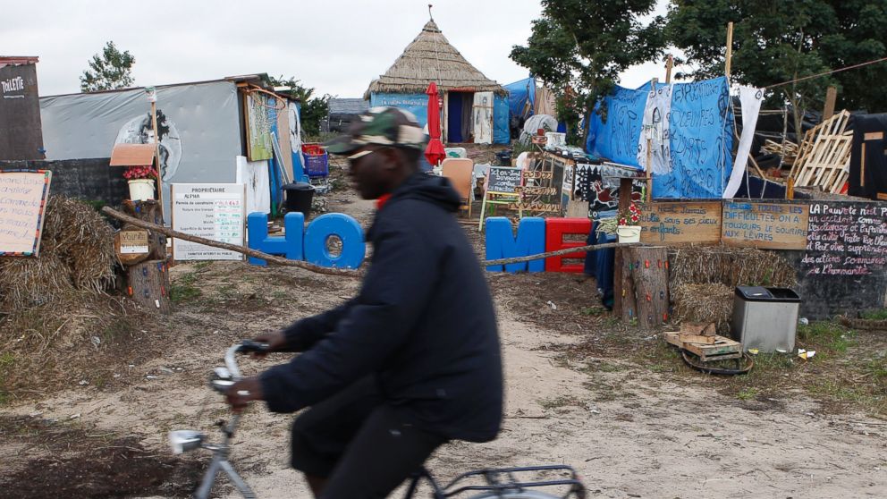 A migrant rides a bicycle past tents near the migrant camp known as the new "Jungle" in Calais, northern France, Sept. 3, 2015.