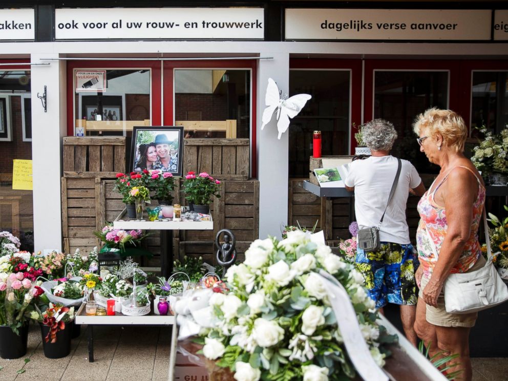 PHOTO: Women stand near a portrait of Neeltje Tol, left, and Cor Schilder, right, placed with flowers and candles in front of their flower shop in Volendam, Netherlands, July 19, 2014.