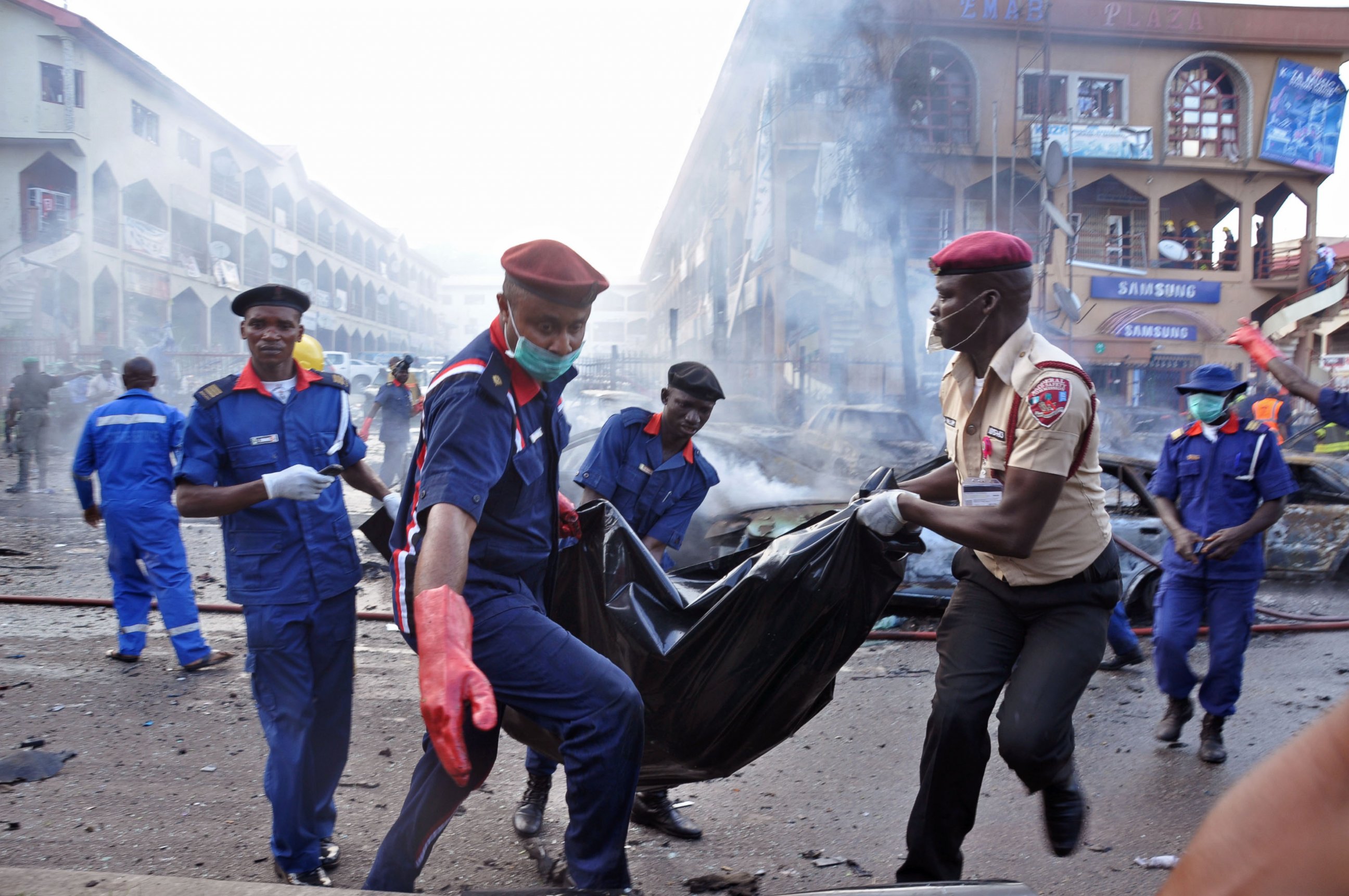 PHOTO: Rescue workers carry a body bag after a explosion at a shopping mall in Abuja, Nigeria