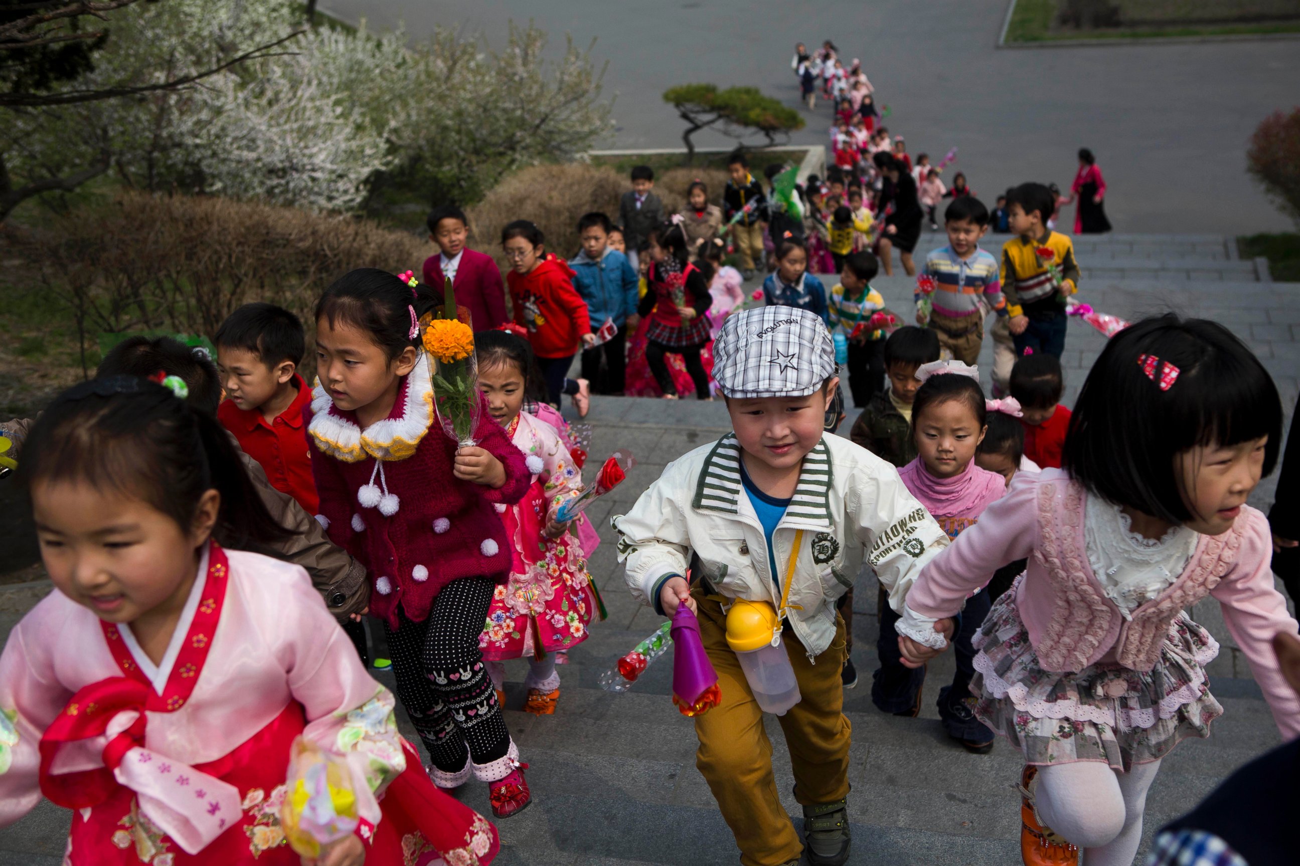 PHOTO: North Korean children climb steps near Mansu Hill on their way to lay flowers at the feet of bronze statues of the late North Korean leaders Kim Il Sung and Kim Jong Il in Pyongyang, North Korea on April 12, 2014.