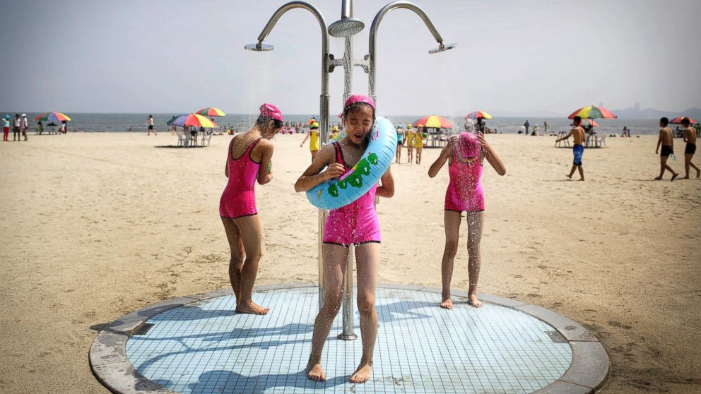 North Korean girls in similar bathing suits stand under a shower at the Songdowon International Children's Camp, July 29, 2014, in Wonsan, North Korea.