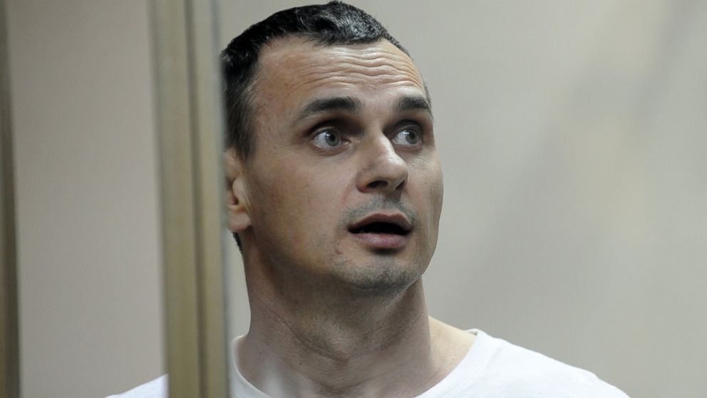 Oleg Sentsov reacts as the verdict is delivered as he stands behind bars at a court in Rostov-on-Don, Russia, Aug. 25, 2015. 