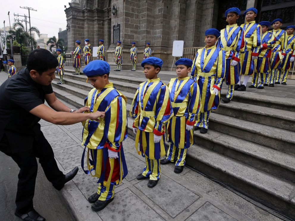 PHOTO: A Catholic priest adjusts the uniform of boys who are dressed as Vatican Swiss guards during a rehearsal for the visit of Pope Francis outside the Manila Cathedral, Jan. 14, 2015 in Manila, Philippines.