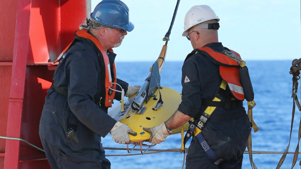 Workers deploy the towed pinger locator off the deck of Australian Defense vessel Ocean Shield in the first search for the missing flight data recorder and cockpit voice recorder in the southern Indian Ocean, April 4, 2014.