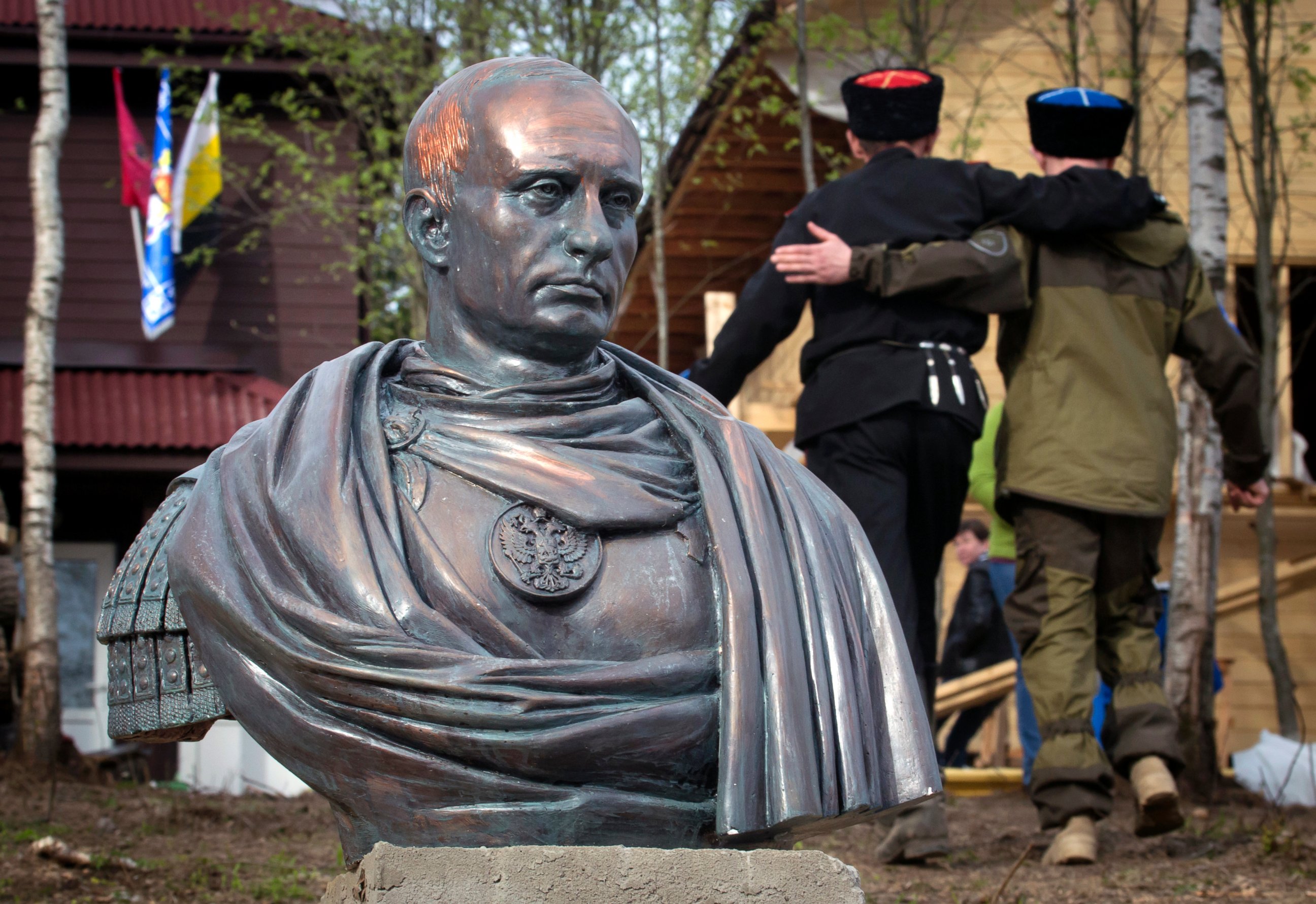 PHOTO: Cossacks walk past a bust of Russian president Vladimir Putin in Kasimovo village, 30 km to the north of St. Petersburg, Russia,  May 16, 2015.