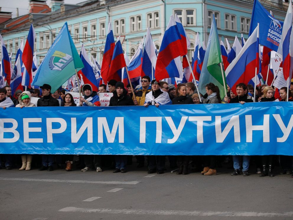 PHOTO: Demonstrators hold Russian flags and a poster We trust Putin during a demonstration in support of Kremlin-backed plans for the Ukrainian province of Crimea to break away and merge with Russia, in Moscow, Saturday, March 15, 2014.