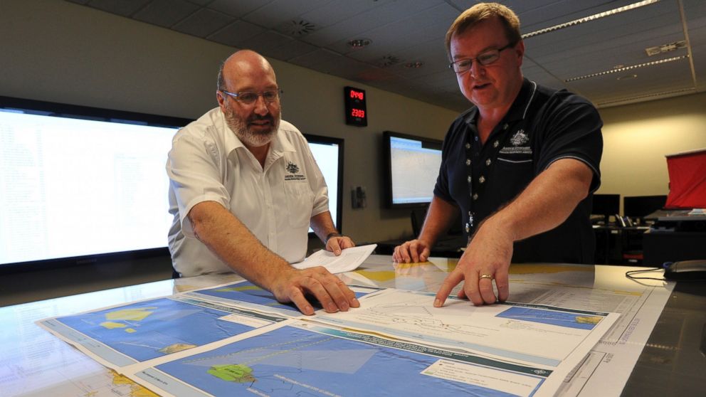 Mike Barton, rescue coordination chief, left, looks over the maps of the Indian Ocean with Alan Lloyd, manager of search and rescue operations at the Australian Maritime Safety Authority's rescue coordination center in Canberra, March 23. 2014. 