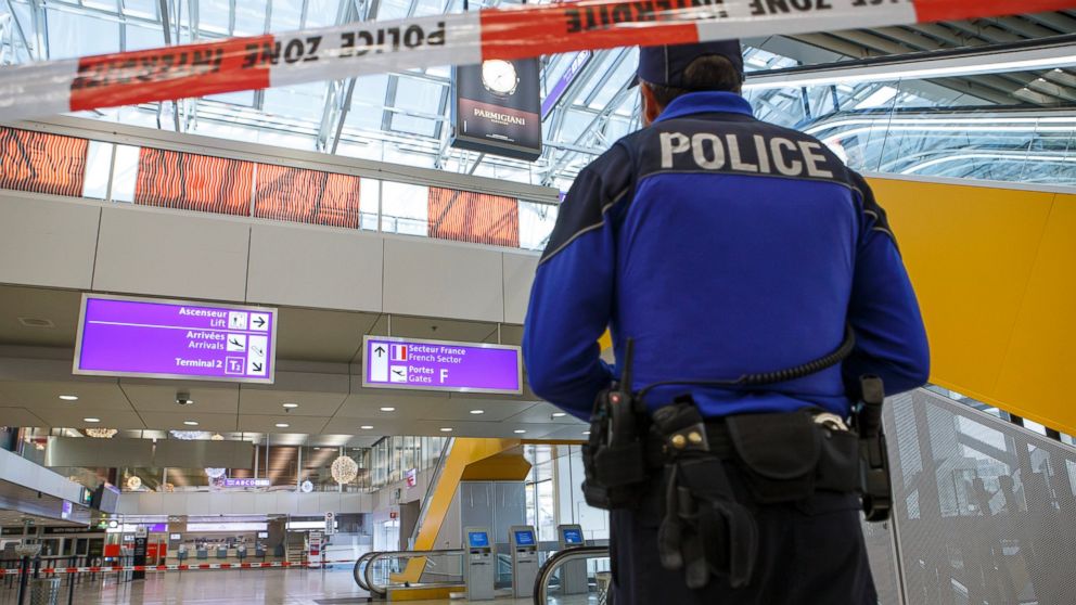 A Swiss police officer observes an area at the Geneva airport after finding an abandoned luggage during a high level of alert, in Geneva, Switzerland, Dec. 11, 2015. 