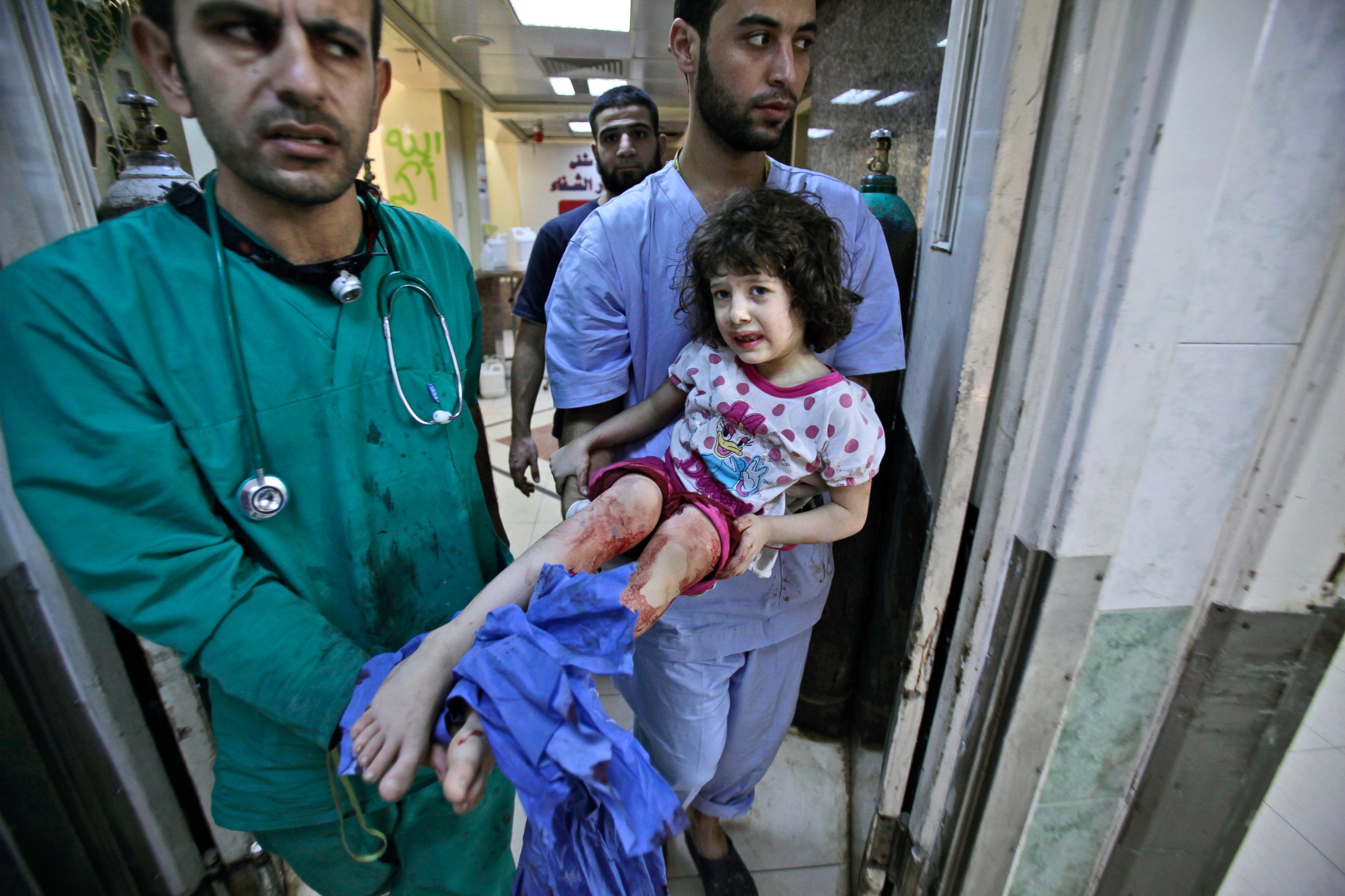 PHOTO: Medics carry Fatima Qassim, 6, who was badly injured in her legs after government forces fired on her family's car, to the emergency room in a hospital in Aleppo, Syria, Sept. 11, 2012. 
