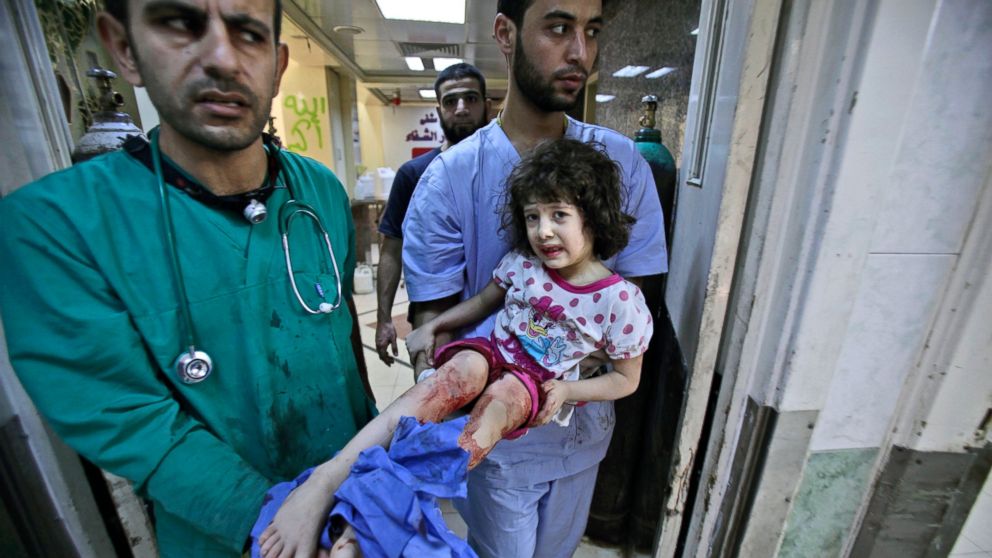 Medics carry Fatima Qassim, 6, who was badly injured in her legs after government forces fired on her family's car, to the emergency room in a hospital in Aleppo, Syria, Sept. 11, 2012. 