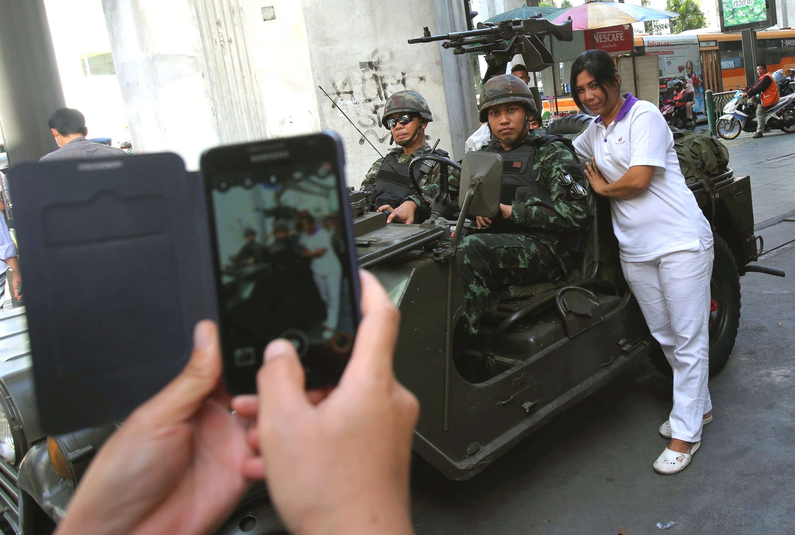 PHOTO: A Thai woman take pictures with Thai soldiers stationed outside the Thai police headquarters, May 20, 2014, in Bangkok.