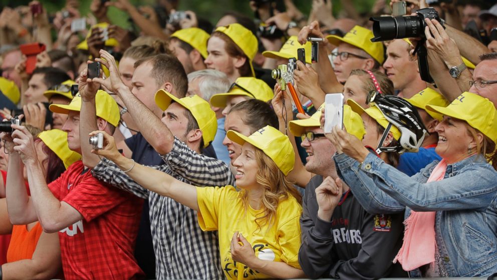 PHOTO: Spectators take pictures of the podium ceremony of the third stage of the Tour de France cycling race over 155 kilometers (96.3 miles) with start in Cambridge and finish in London, England, July 7, 2014.