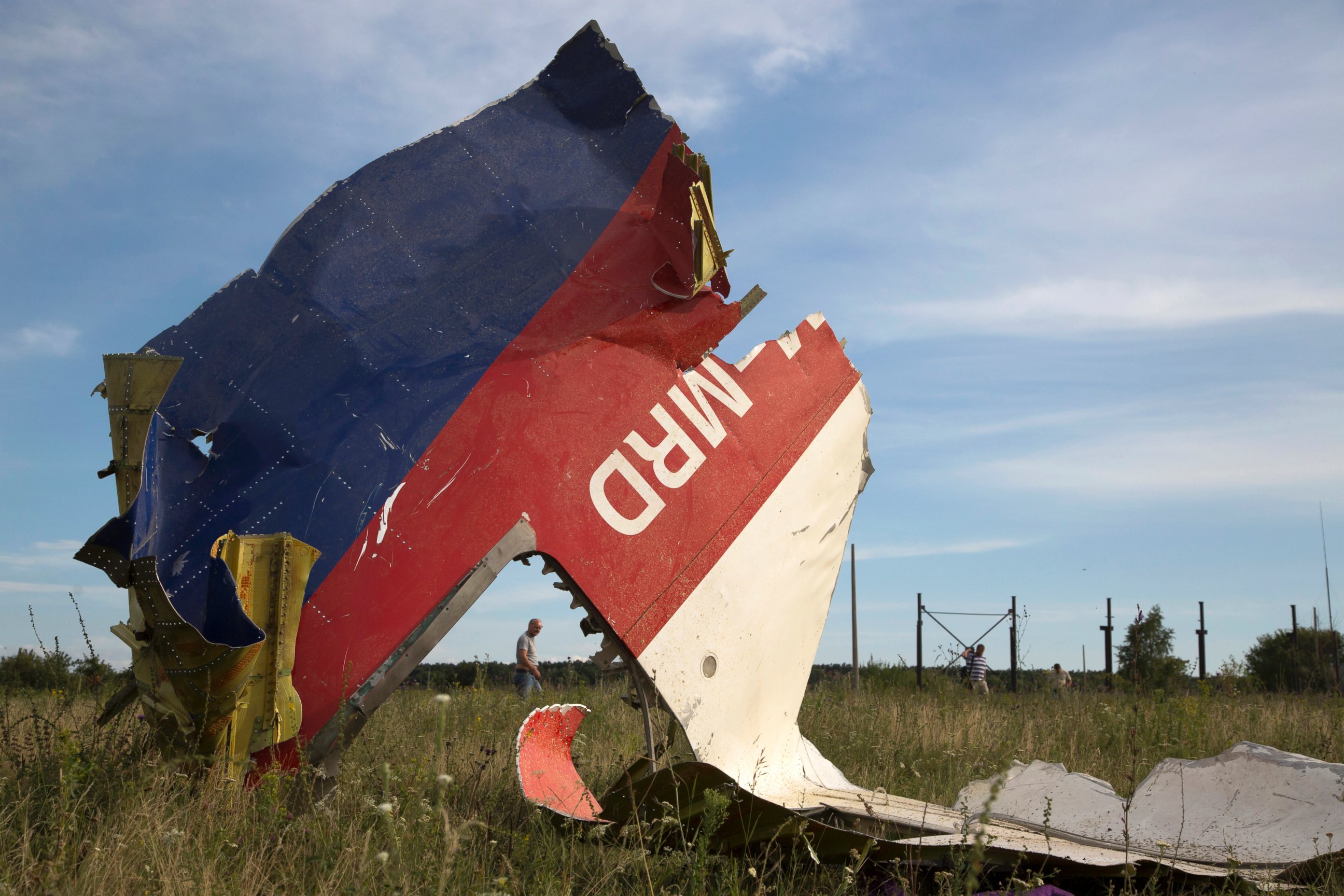 PHOTO: A man walks past a piece of the crashed Malaysia Airlines Flight 17 near the village of Hrabove, eastern Ukraine,  July 21, 2014.