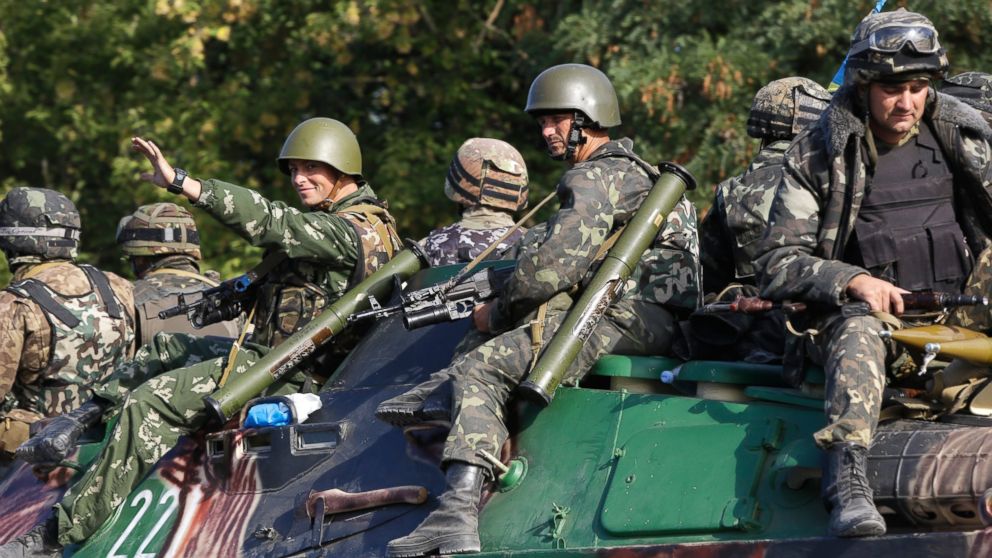 Ukrainian soldiers ride atop an APC near the village of Sakhanka, eastern Ukraine, Aug. 27, 2014. 