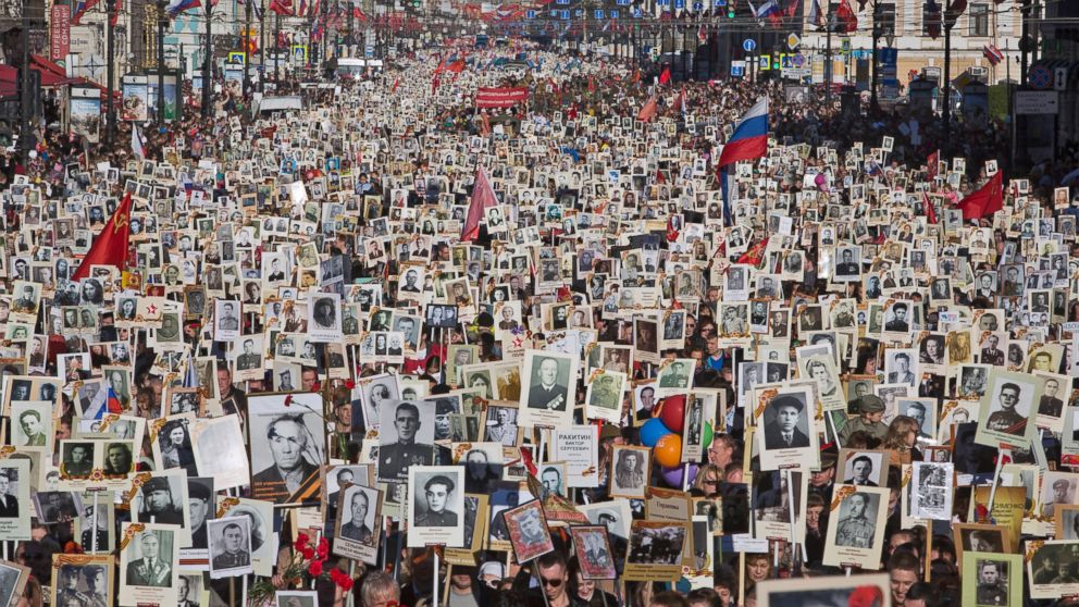 Local residents carry portraits of their ancestors, participants in World War Two as they celebrate the 70th anniversary of the defeat of the Nazis in World War II in St. Petersburg, Russia, Saturday, May 9, 2015.