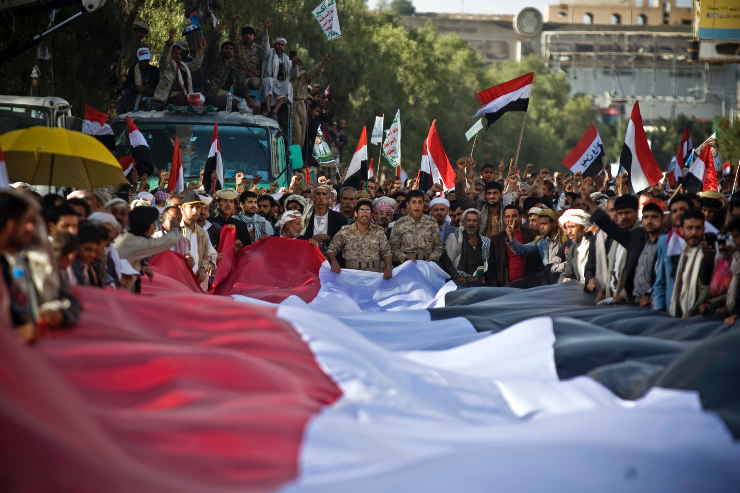 PHOTO: Houthi Shiite Yemenis hold carry a large representation of the national flag during a celebration marking the fourth anniversary of the revolution in Sanaa, Yemen, Feb. 11, 2015.