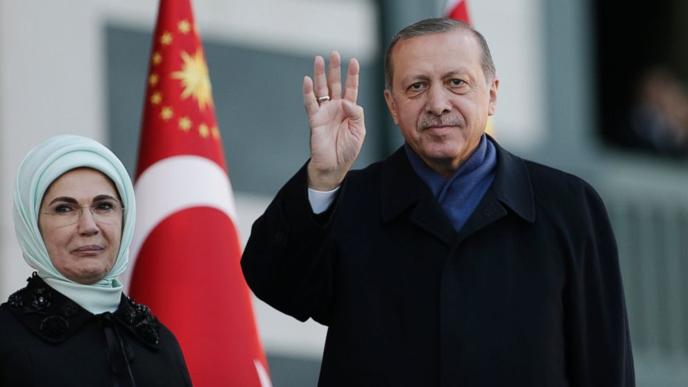 Turkish President Recep Tayyip Erdogan, accompanied by his wife Emine, left, waves to supporters prior to his speech during a rally one day after the referendum, outside the presidential palace, April 17, 2017, in Ankara, Turkey. A landmark referendum granted sweeping new powers to Erdogan.