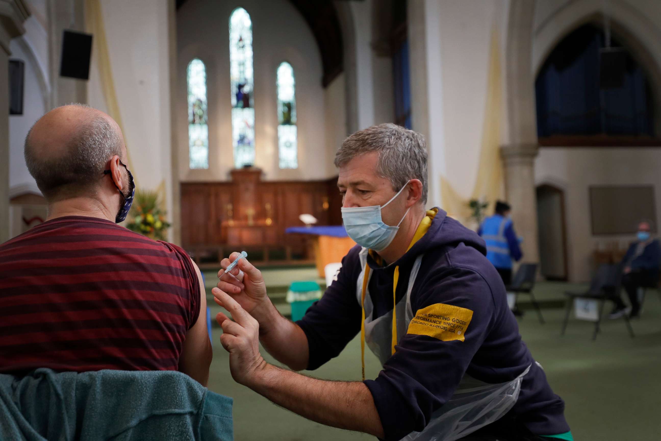 PHOTO: Nick Gray, a St Johns Ambulance vaccinator gives the AstraZeneca vaccine at St John's Church, in Ealing, London, March 16, 2021. 