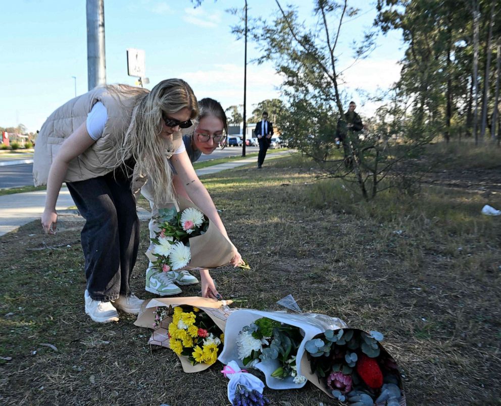 PHOTO: Two women lay flowers on the side the road in Cessnock, in Australia's Hunter wine region north of Sydney on June 12, 2023.