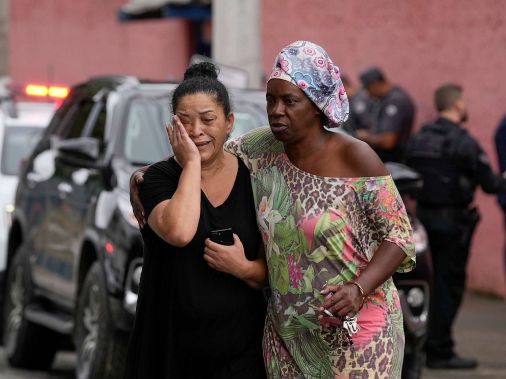 PHOTO: Silvia Palmieri, who is the mother of a teacher who survived a stabbing attack at the Thomazia Montoro school, left, leaves the school comforted by a friend in Sao Paulo, Brazil, March 27, 2023.