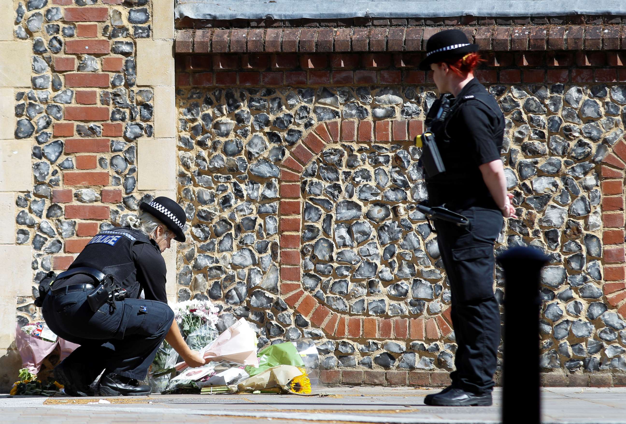 PHOTO: A police officer lays flowers near to the scene of reported multiple stabbings in Reading, Britain, June 22, 2020. 