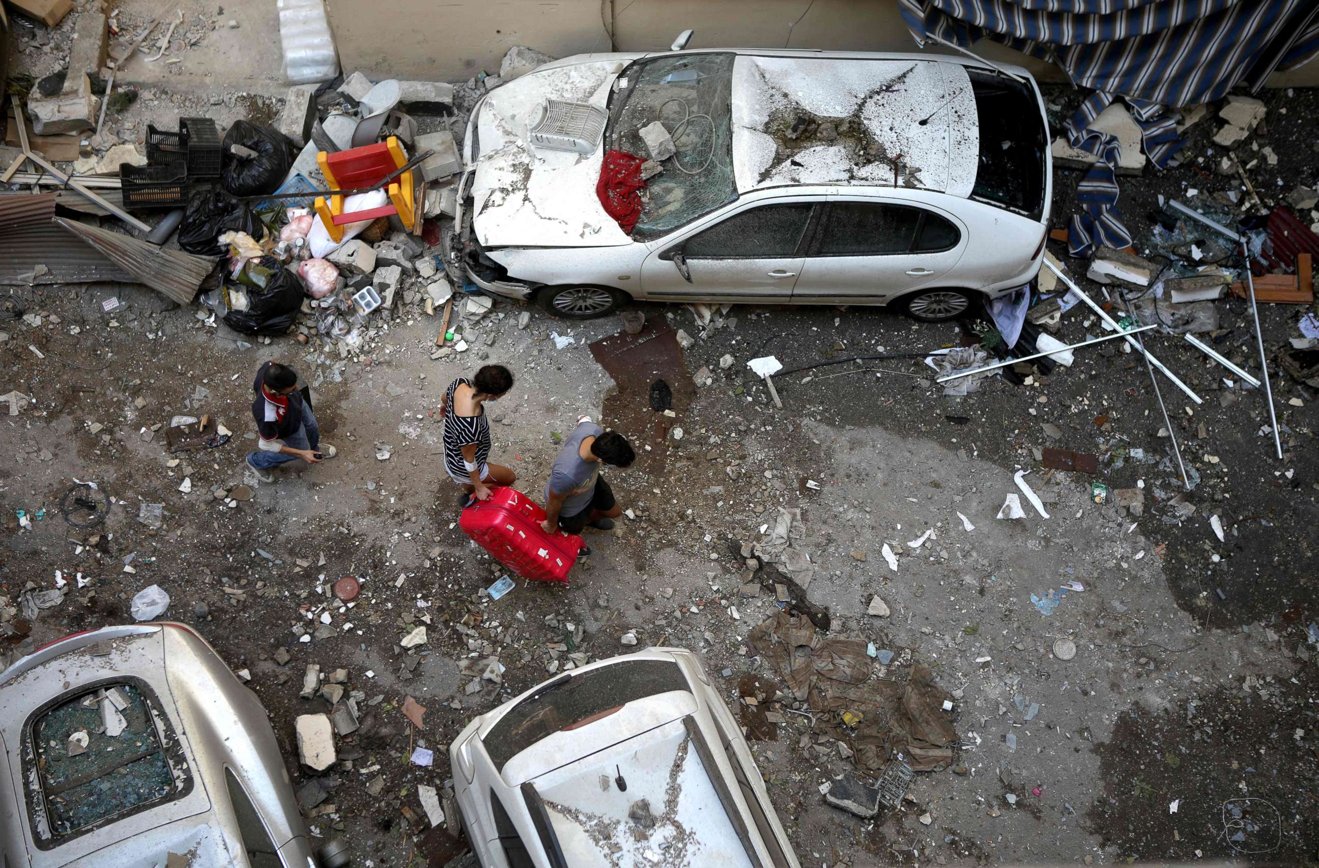 PHOTO: Lebanese carry a suitcase as they leave their damaged apartment in the trendy Beirut neighbourhood of Mar Mikhael on August 6, 2020 in the aftermath of a massive explosion in the Lebanese capital. 