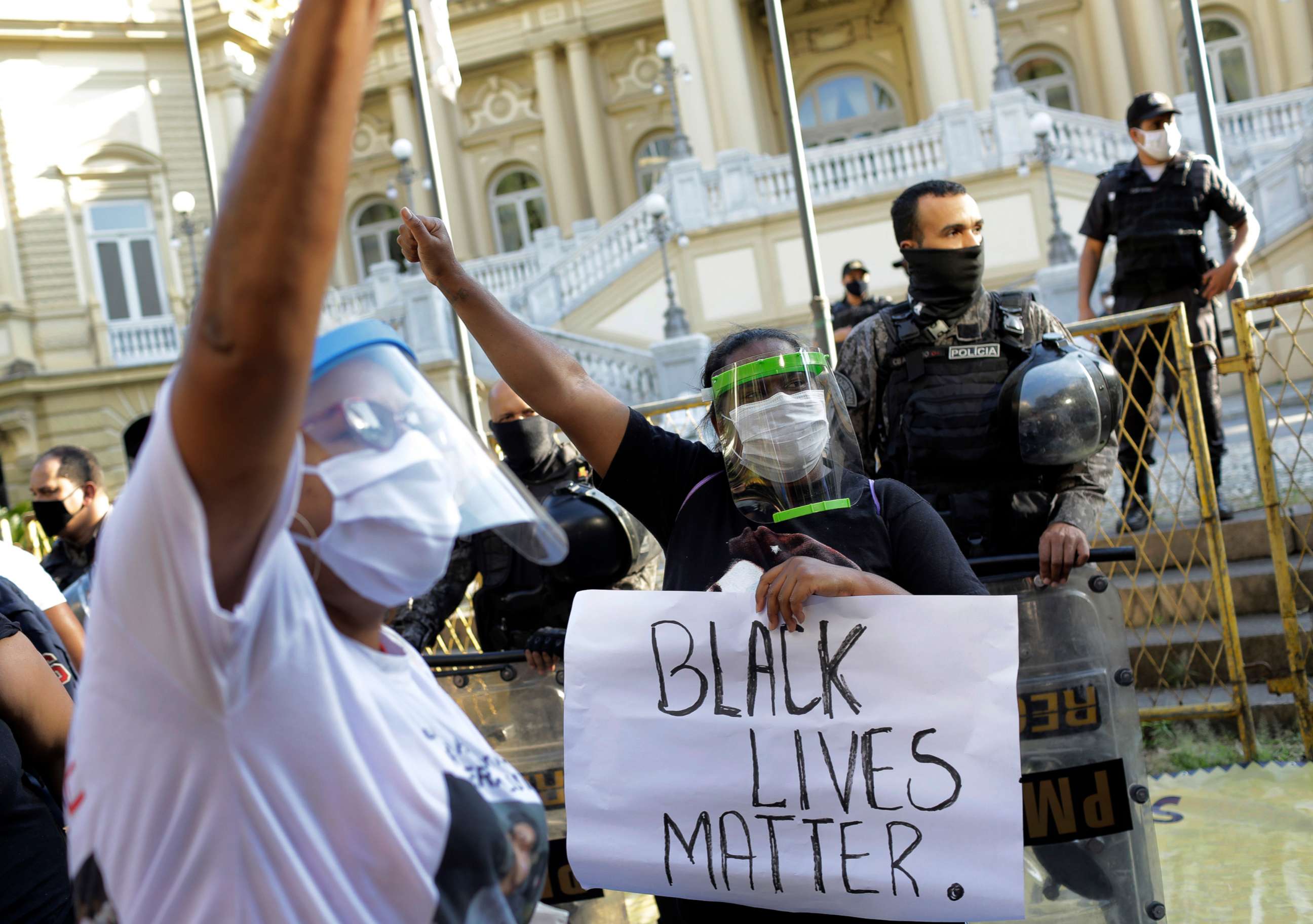 PHOTO: Women wearing face shields against the spread of the new coronavirus, protest against crimes committed by the police against black people in the favelas, outside the Rio de Janeiro's state government, Brazil, Sunday, May 31, 2020. 