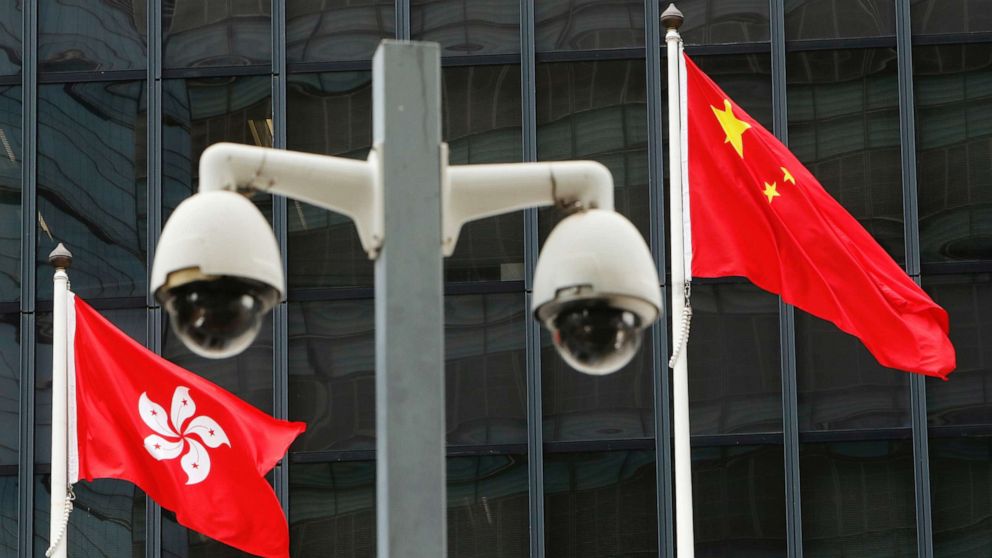 FILE PHOTO: Hong Kong and Chinese national flags are flown behind a pair of surveillance cameras outside the Central Government Offices in Hong Kong, China July 20, 2020.