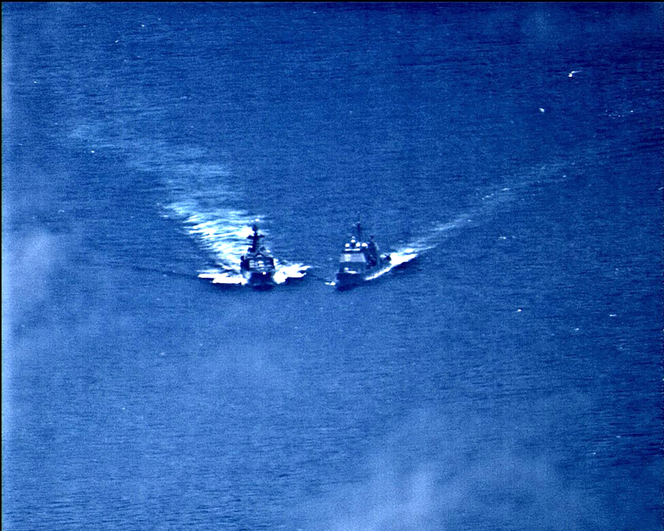 PHOTO: A surveillance photo shows a Russian naval destroyer making what the U.S. Navy describes as an unsafe maneuver against the Ticonderoga-class guided-missile cruiser USS Chancellorsville in the Philippine Sea, June 7, 2019.
