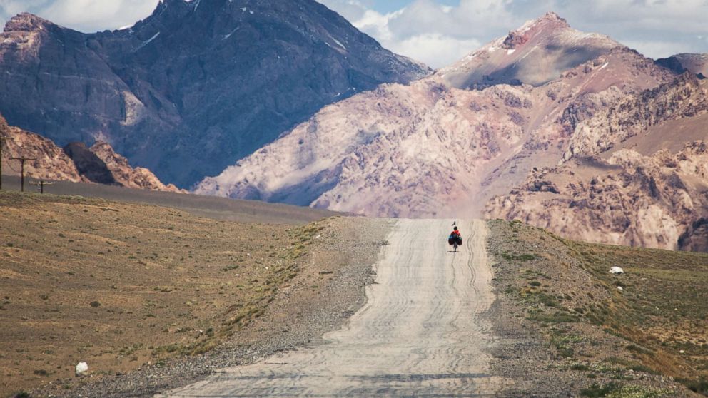 A traveler on the M41 road (also called Pamir highway), crossing the Pamir plateau in Tajikistan.