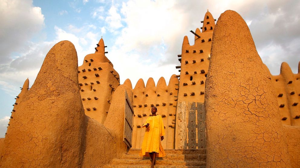 A man exits the largest mud-brick building in the world, the Grand Mosque, in the ancient town of Djenne, Mali in this April 29, 2007 file photo.