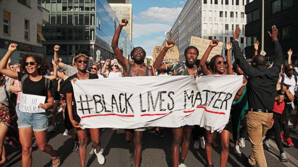 PHOTO: Demonstrators hold a banner with the motto of the black civil rights movement 'Black Lives Matter' to show their solidarity with African Americans in the USA, in Berlin, Germany, July 10, 2016.