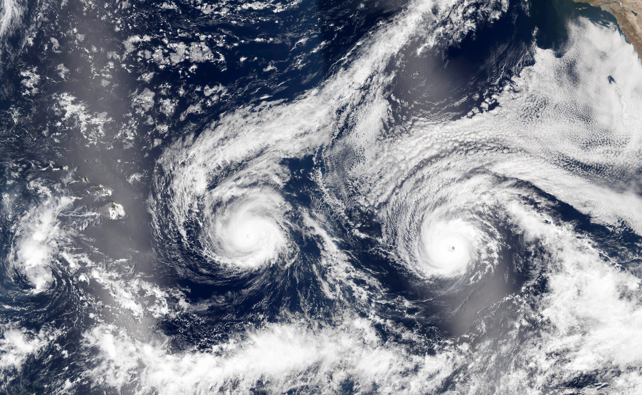 PHOTO: A handout image released by NASA Earth Observatory on Aug. 31, 2016 shows a satellite image of hurricanes Madeline (L) and Lester (R) over the Pacific Sea near Hawaii.