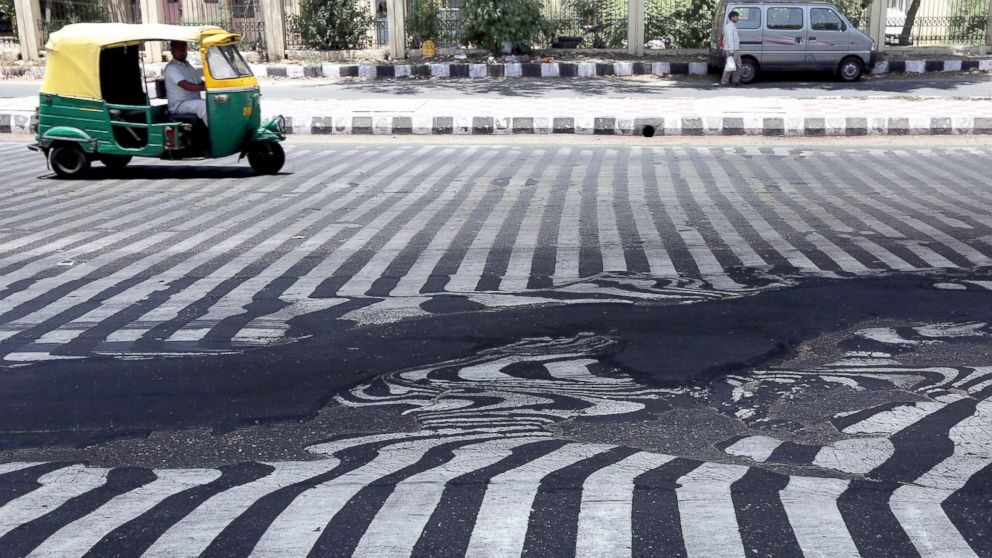 Road markings appear distorted as the asphalt starts to melt due to the high temperature in New Delhi, May 27, 2015.