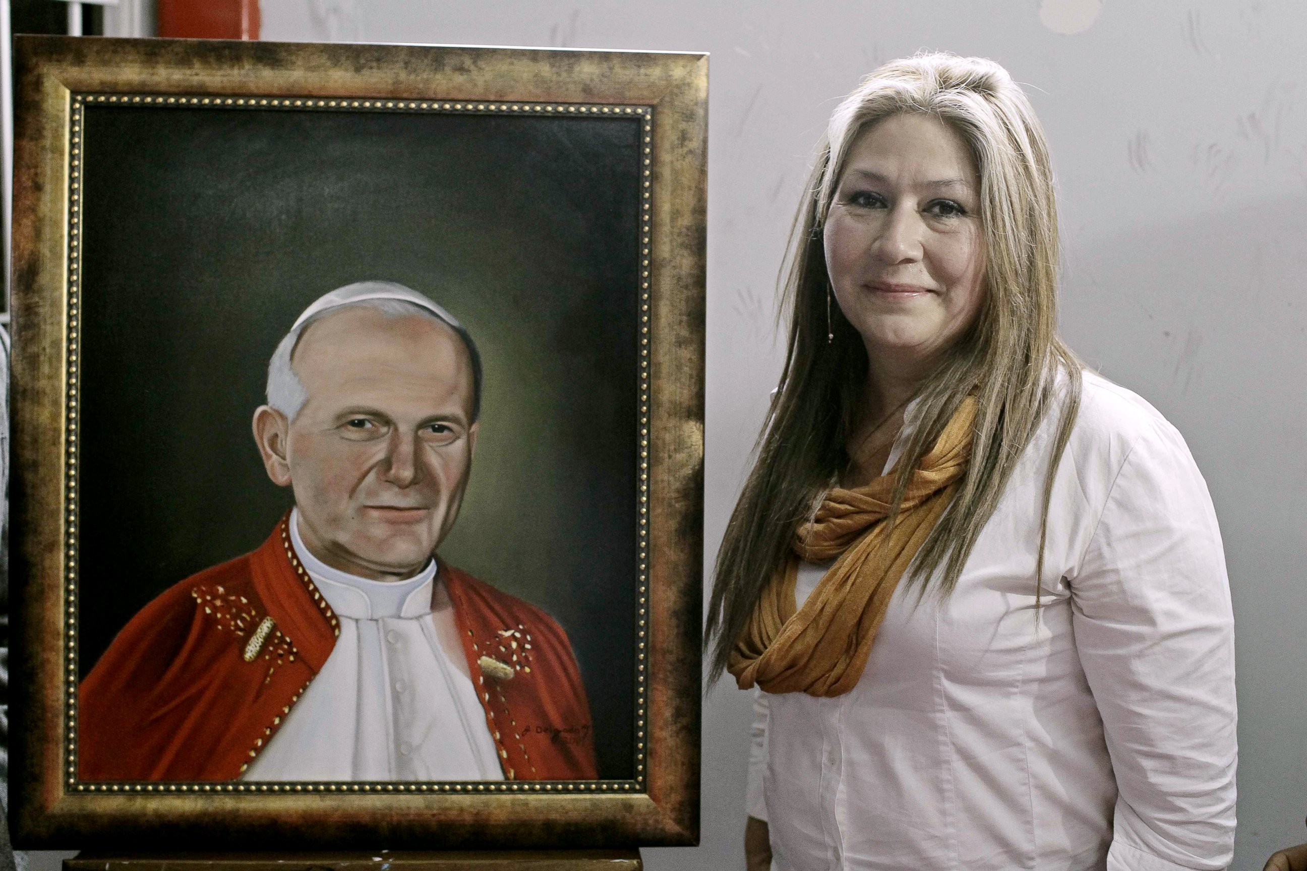 PHOTO: Costa Rican citizen Floribeth Mora, who was healed from a brain aneurysm through a miracle that is attributed to Pope John Paul II, poses next to a portrait of him during a press conference in San Jose, Costa Rica, April 22, 2014.