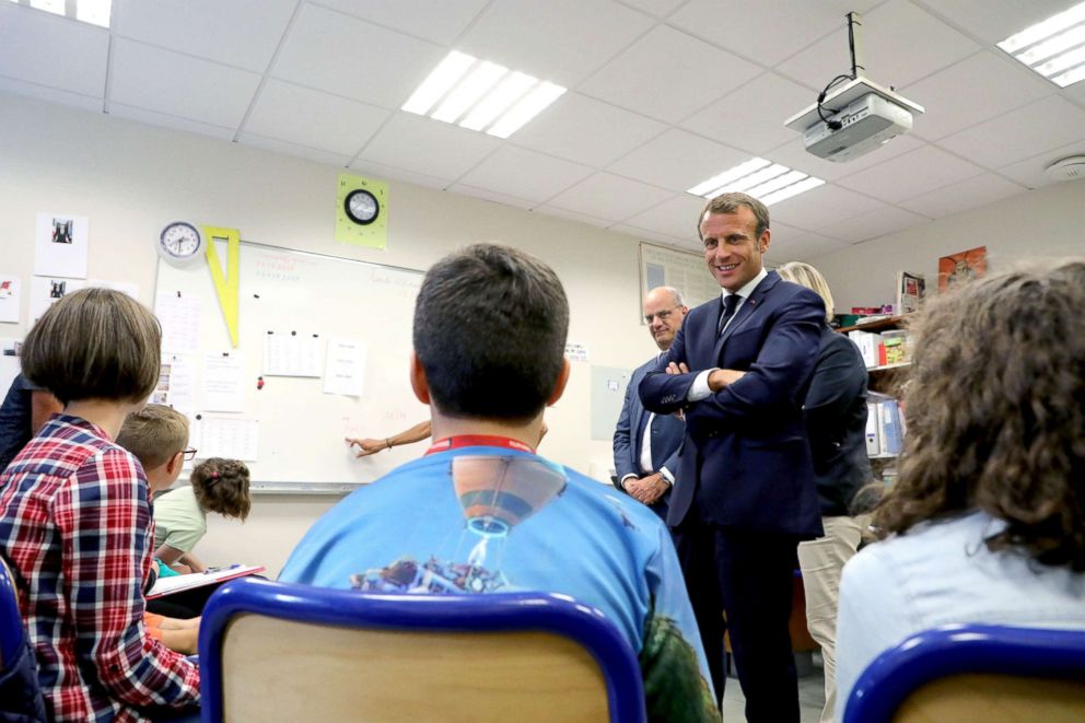 PHOTO: French president Emmanuel Macron, flanked by French Education Minister Jean-Michel Blanquer, speaks with the pupils of the localised educational inclusion units class at the Jules Renard secondary school in Laval, France, Sept. 3, 2018. 