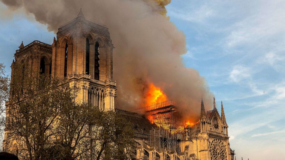 PHOTO: FILE - In this April 15, 2019, file photo, the Notre Dame Cathedral burns in Paris. The cathedral stands crippled, locked in a dangerous web of twisted metal scaffolding one year after a cataclysmic fire.