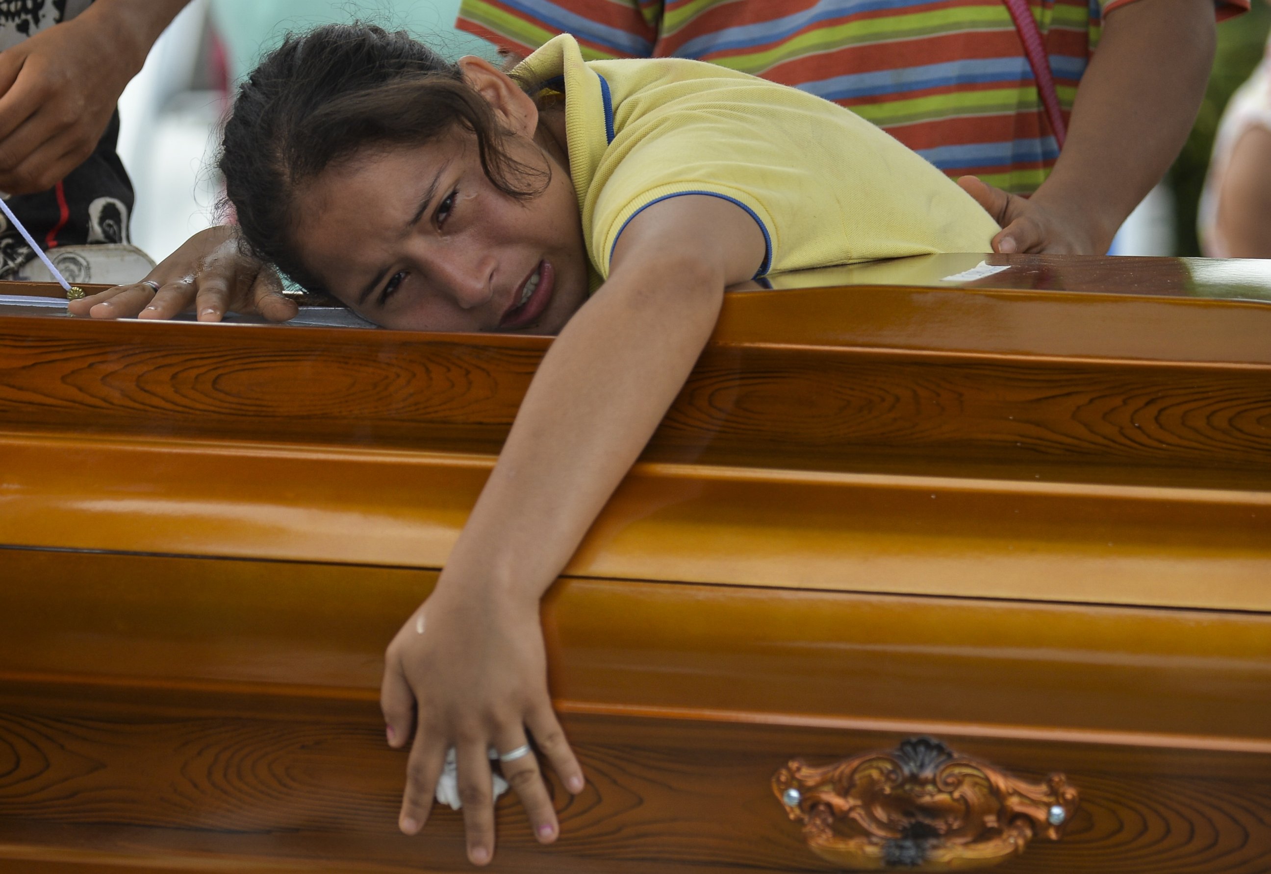PHOTO: A woman mourns over the coffin of her father killed by a mudslide caused by heavy rains, at the cemetery in Mocoa, Putumayo department, Colombia, on April 3, 2017.