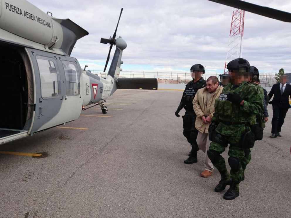 PHOTO: Handout picture released by the Mexican Interior Ministry on Jan. 20, 2017, shows Joaquin Guzman Loera aka El Chapo Guzman (C) being escorted by Mexican police forces as he is extradited to the United States on Jan. 19, 2017, in Ciudad Juarez.