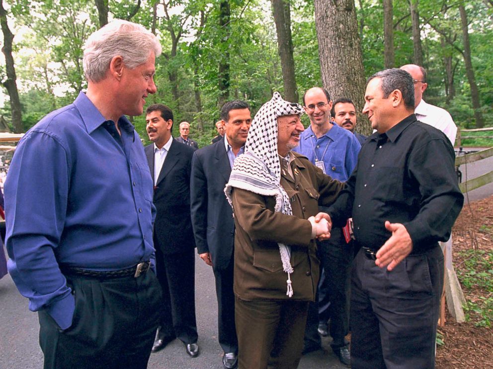PHOTO: President Bill Clinton looks on while Palestinian leader Yasser Arafat and Israeli Prime Minister Ehud Barak shake hands on the opening day of the Mid-East peace talks July 11, 2000 at Camp David MD. 