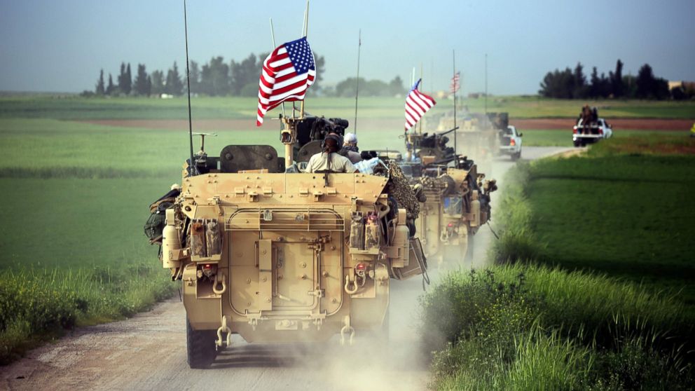 U.S. forces, accompanied by Kurdish People's Protection Units (YPG) fighters, drive their armored vehicles near the northern Syrian village of Darbasiyah, on the border with Turkey, on April 28, 2017. 