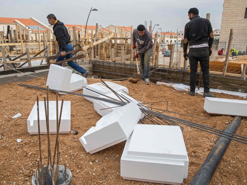 PHOTO: Palestinian labourers work at the construction site of a new housing project in the Israeli settlement of Ariel near the West Bank city of Nablus, on Jan. 25, 2017.