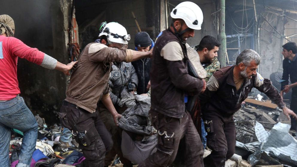 Syrian men and Civil Defense volunteers, also known as the White Helmets, evacuating a victim from a building following an air strike on the village of Maaret al-Numan, in the country's northern province of Idlib, Dec. 4, 2016.