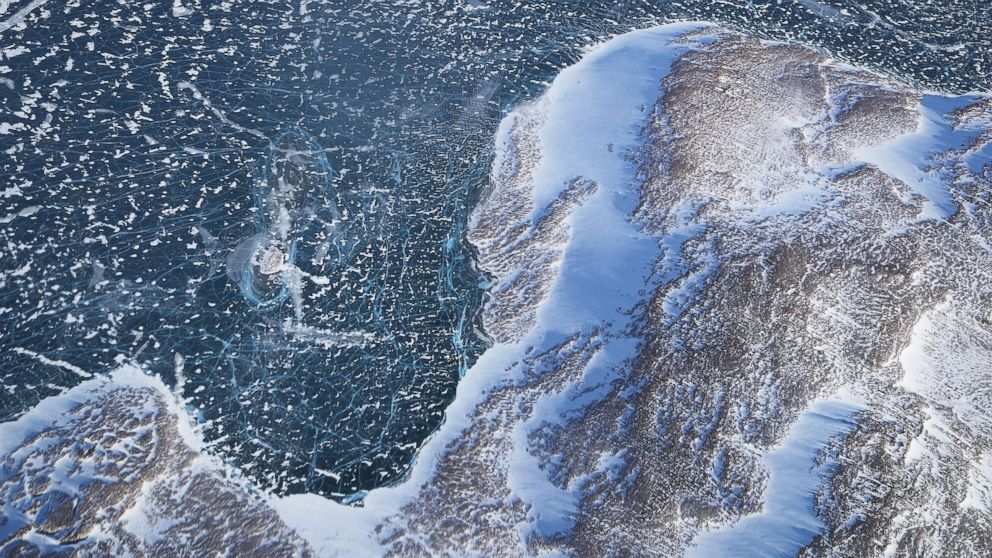 Sea ice (TOP) meets land as seen from NASA's Operation IceBridge research aircraft along the Upper Baffin Bay coast, March 27, 2017, above Greenland.