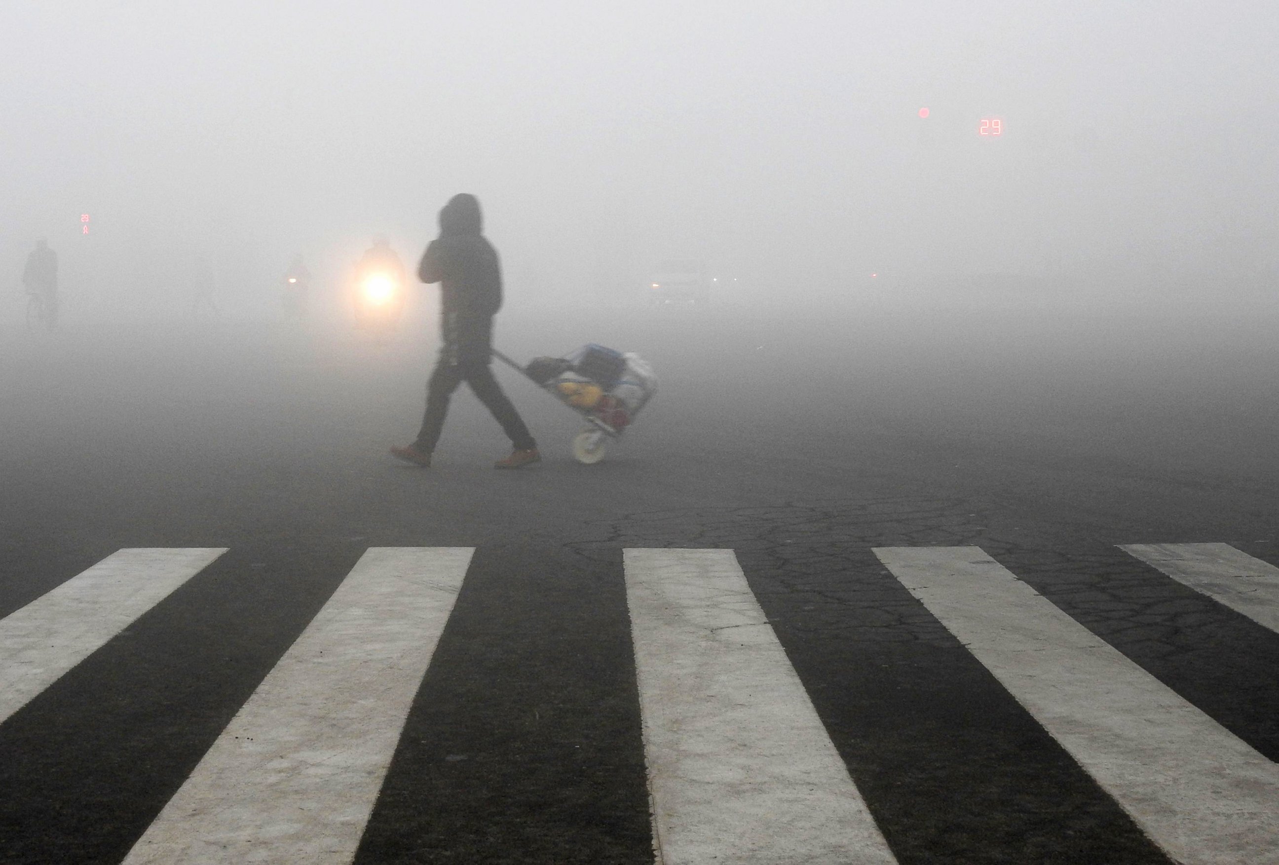 PHOTO: A pedestrian crosses a smog-shrouded street in Lianyungang, eastern China's Jiangsu province, Dec. 19, 2016. 