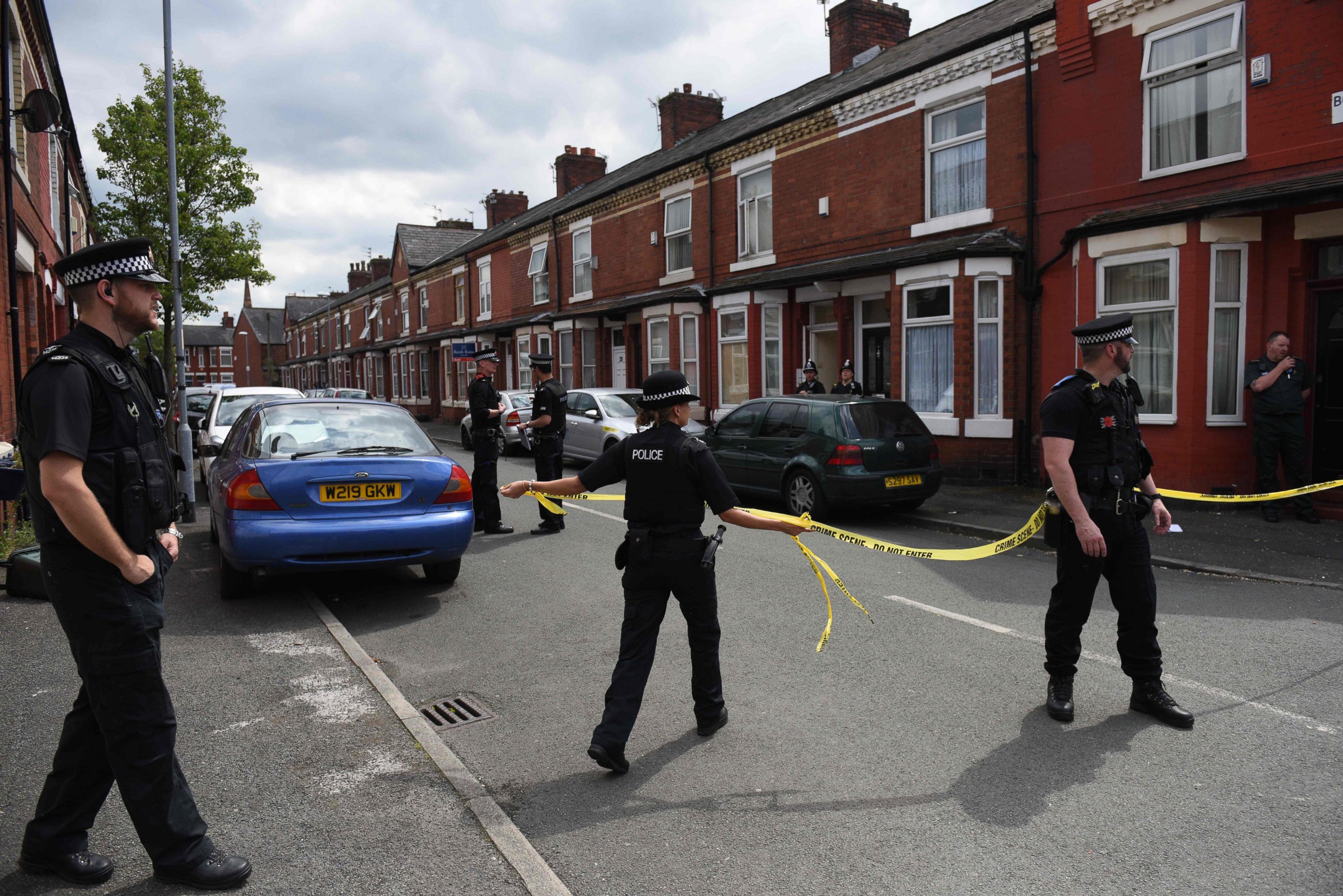 PHOTO: Police officers set a cordon outside the entrance of a property they entered in the Moss Side area of Manchester, May 27, 2017 during an operation. 
