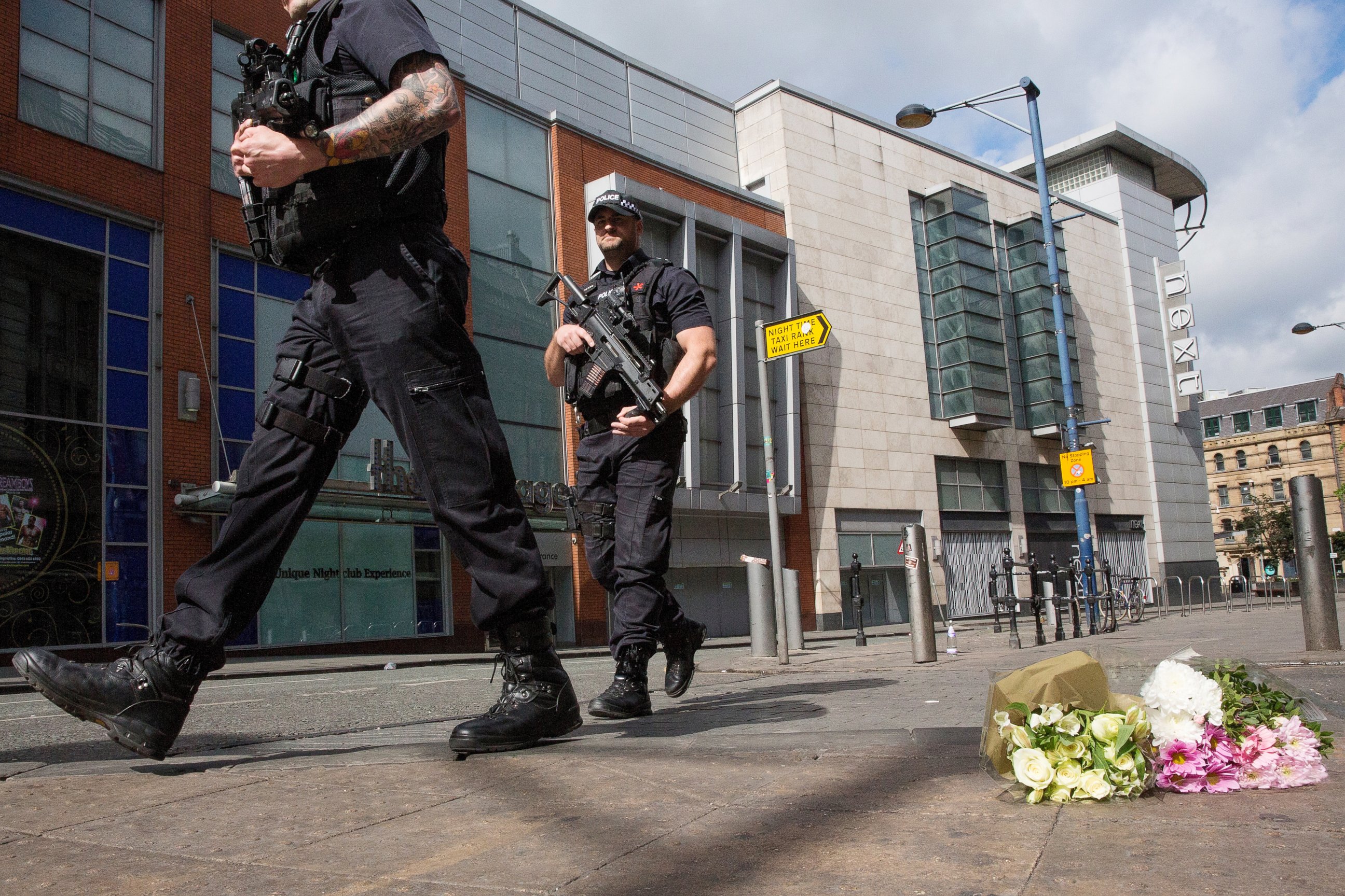 PHOTO: Armed police patrol Shudehill as they walk past floral tributes to victims, May 23, 2017, in Manchester, England.