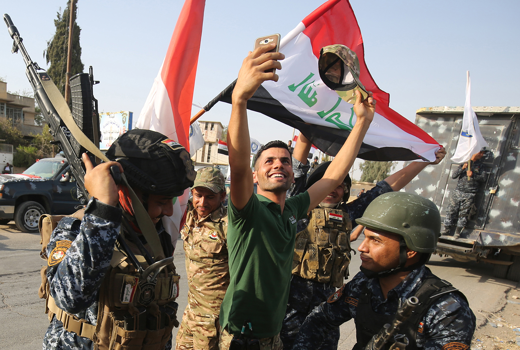 PHOTO: An Iraqi man takes a selfie with federal police members as they celebrate in the Old City of Mosul on July 9, 2017 after the government's announcement of the "liberation" of the embattled city.
