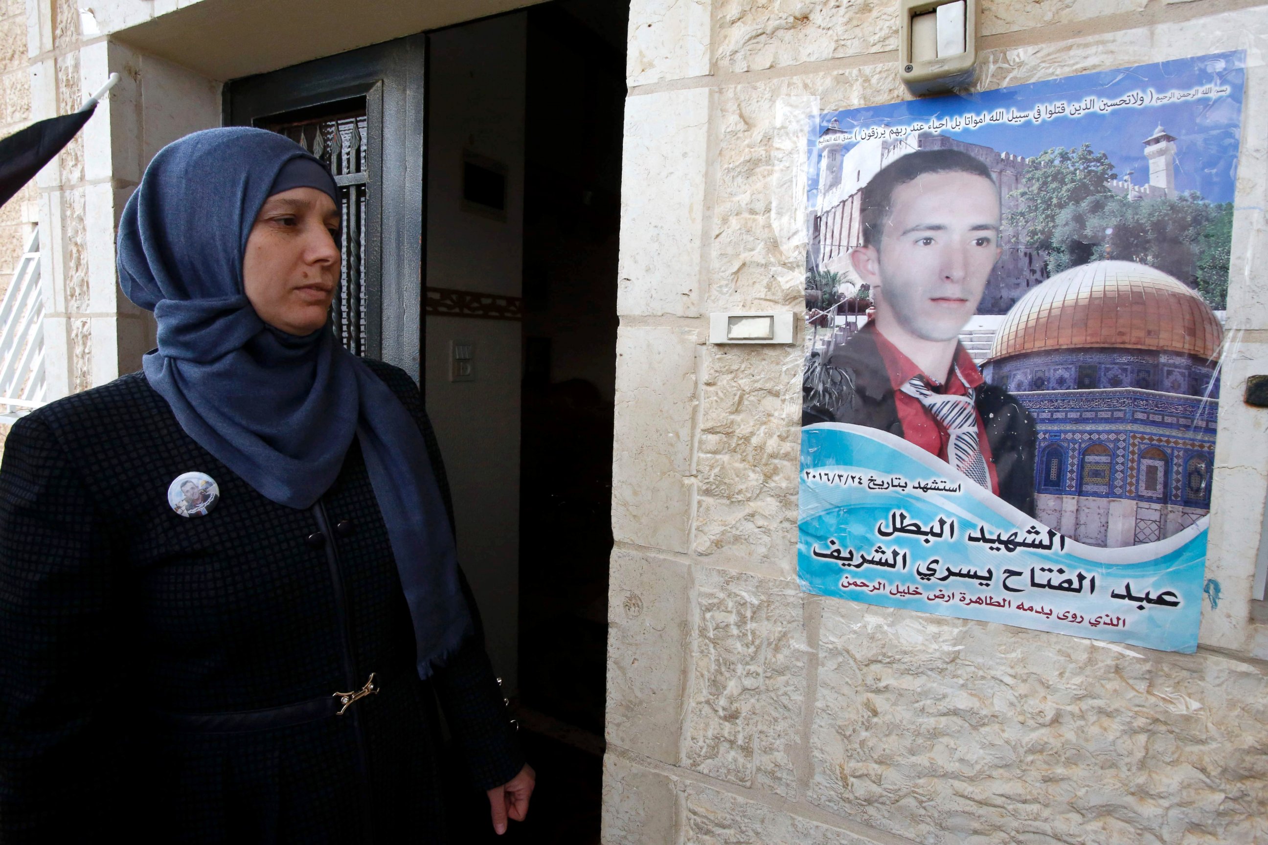 PHOTO: Rajaa looks at a poster of her son Abdel Fattah al-Sharif outside their family home in the West Bank town of Hebron, January 4, 2017, during the trial of Israeli soldier Elor Azaria who killed Sharif.