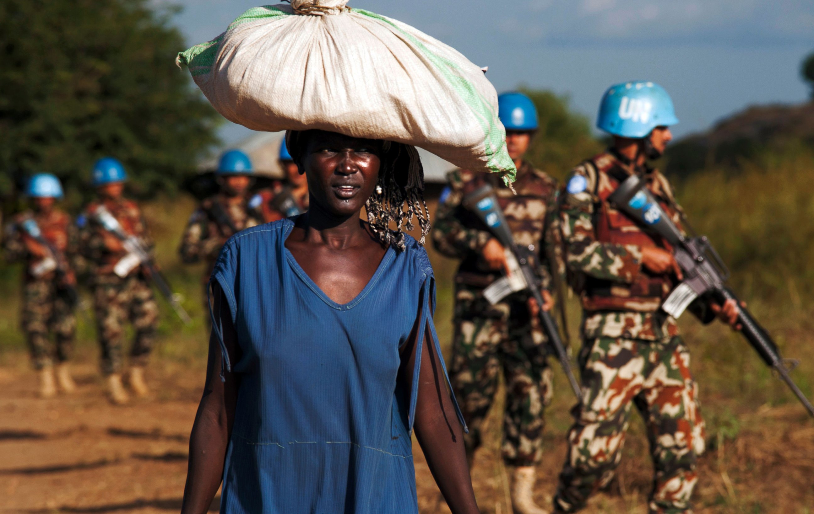 PHOTO: This file photo taken on Oct. 4, 2016 shows a displaced woman carrying goods as United Nations Mission in South Sudan (UNMISS) peacekeepers patrol outside the premises of the UN Protection of Civilians (PoC) site in Juba.